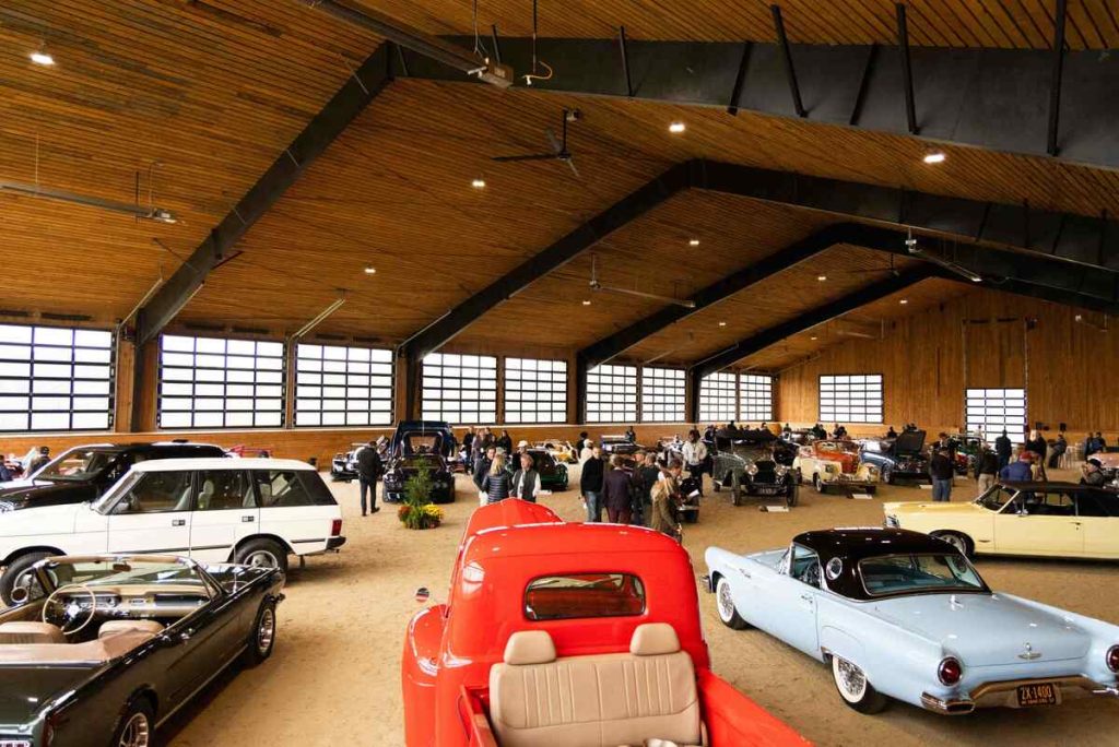 Cars and people in large indoor arena.