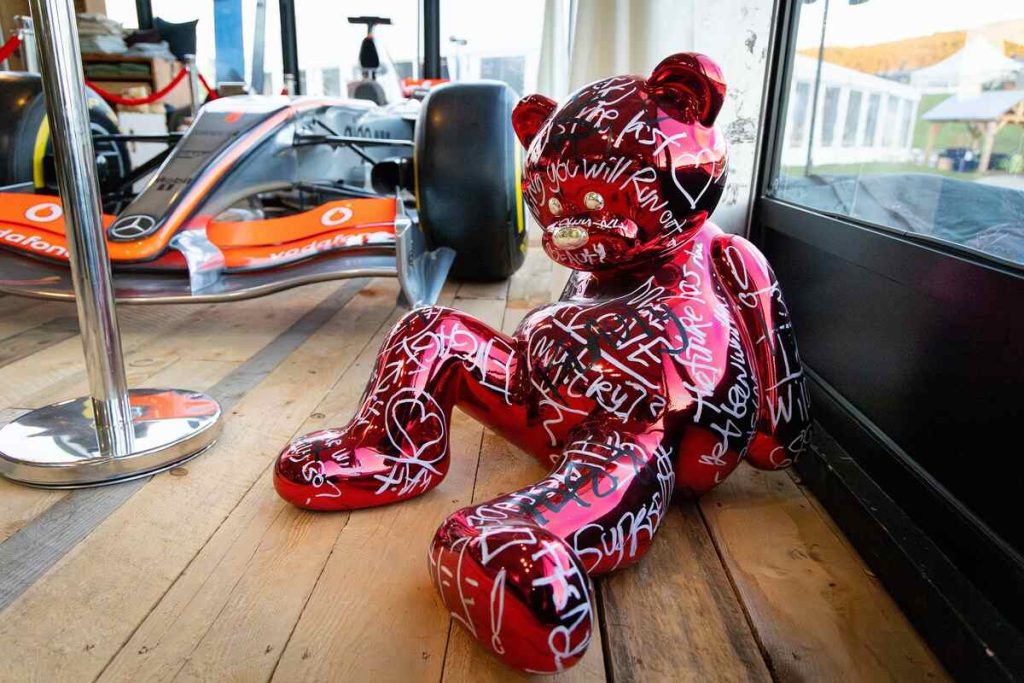 Inflatable pink bear on wood floor.